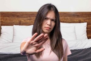 Donna con mano in avanti e letto