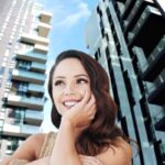 Donna con aria sognante e palazzi di Milano