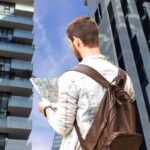 Uomo con cartina e alti palazzi