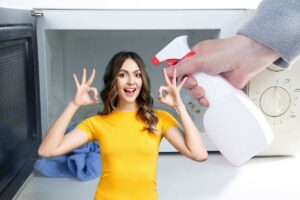 donna che fa ok con le mani e un'altra che pulisce microonde