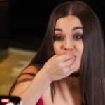 ragazza che mangia mentre qualcuno le fa una foto