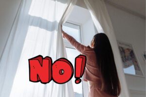 una ragazza che apre le tende di casa e una scritta no