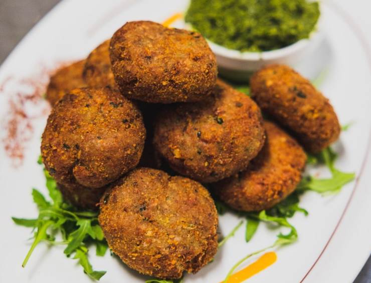 polpette fritte su un piatto con accanto una ciotolina con salsa verde